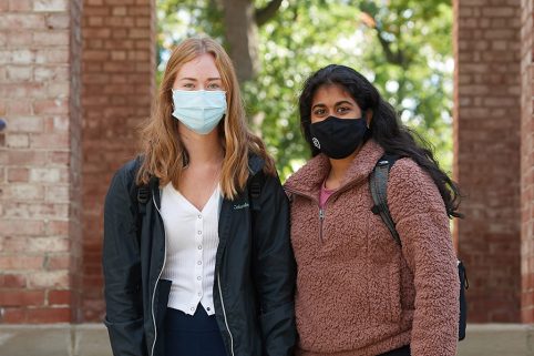 Health & Wellness(图1) Two students standing outside Baldwin Hall wearing masks.